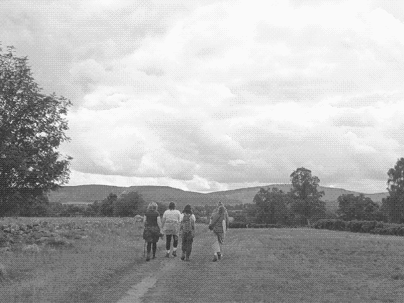 An image of trans women in a wide landscape walking away from the camera.